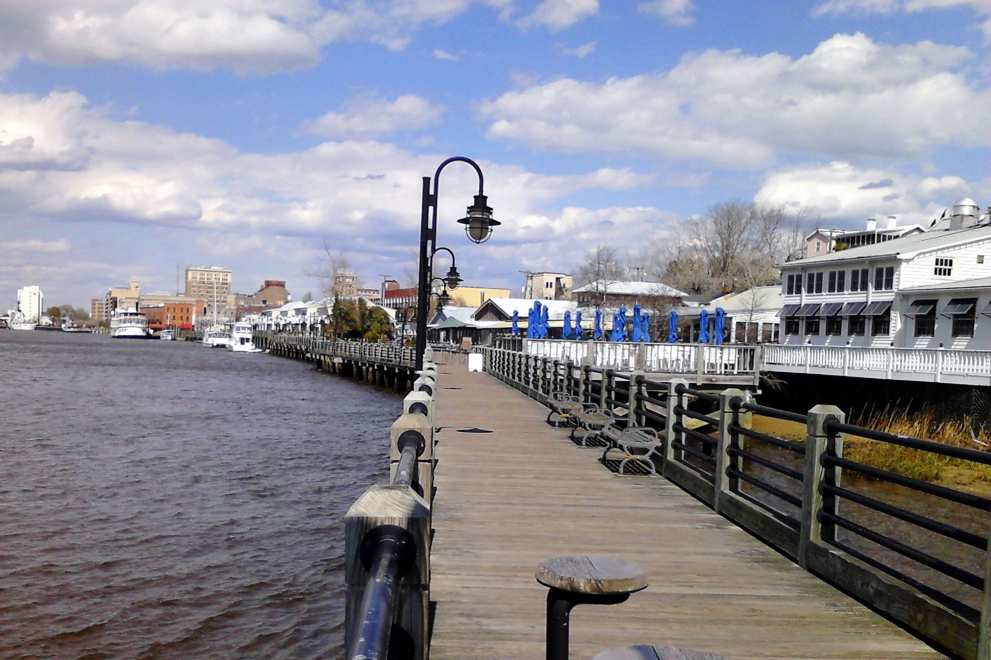 Location photo: Wilmington Riverwalk along the Cape Fear River with downtown buildings (public photo, not a Veras Roofing job photo)