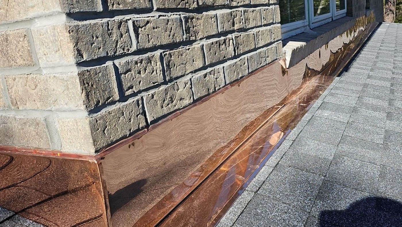 Close copper flashing transition along a roof edge