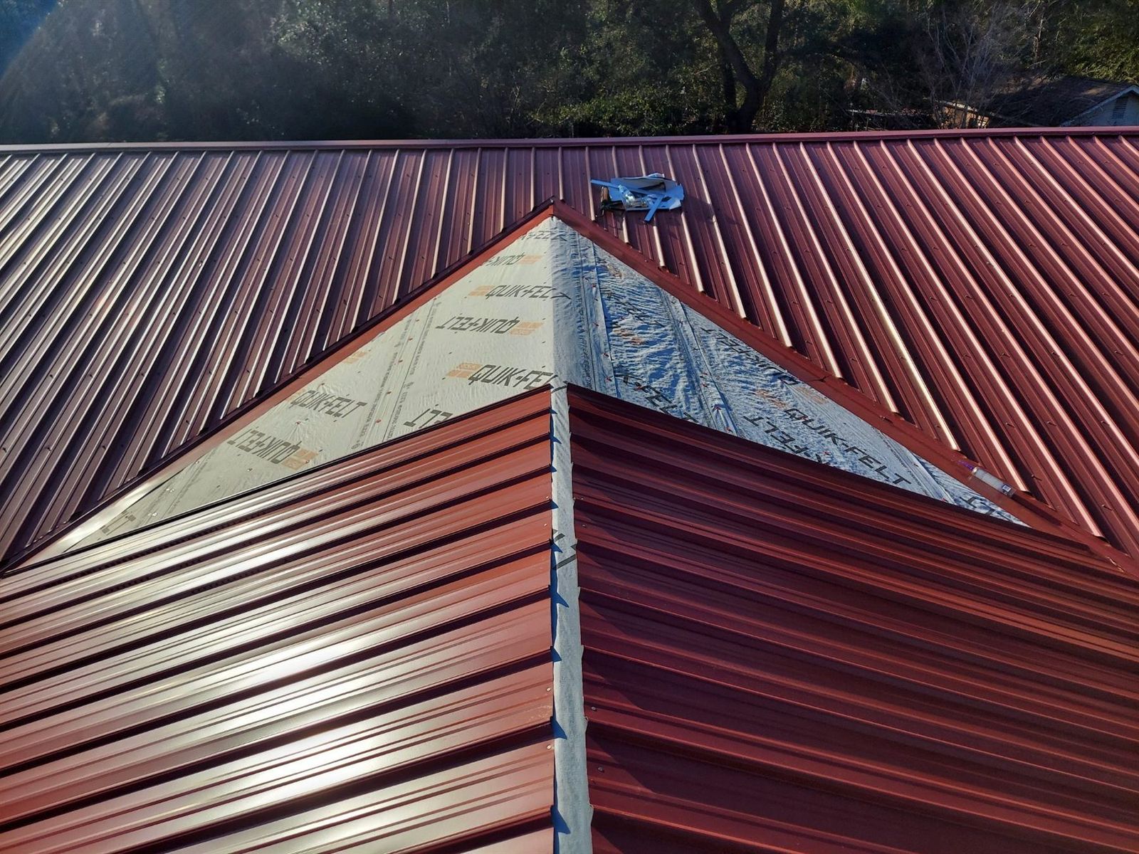 Red metal roof panels with ridge detail visible